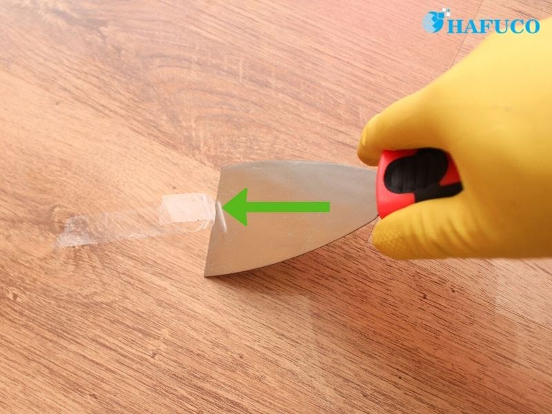 Dùng dụng cụ dẹt, mỏng để lấy sạch bã kẹo cao su
